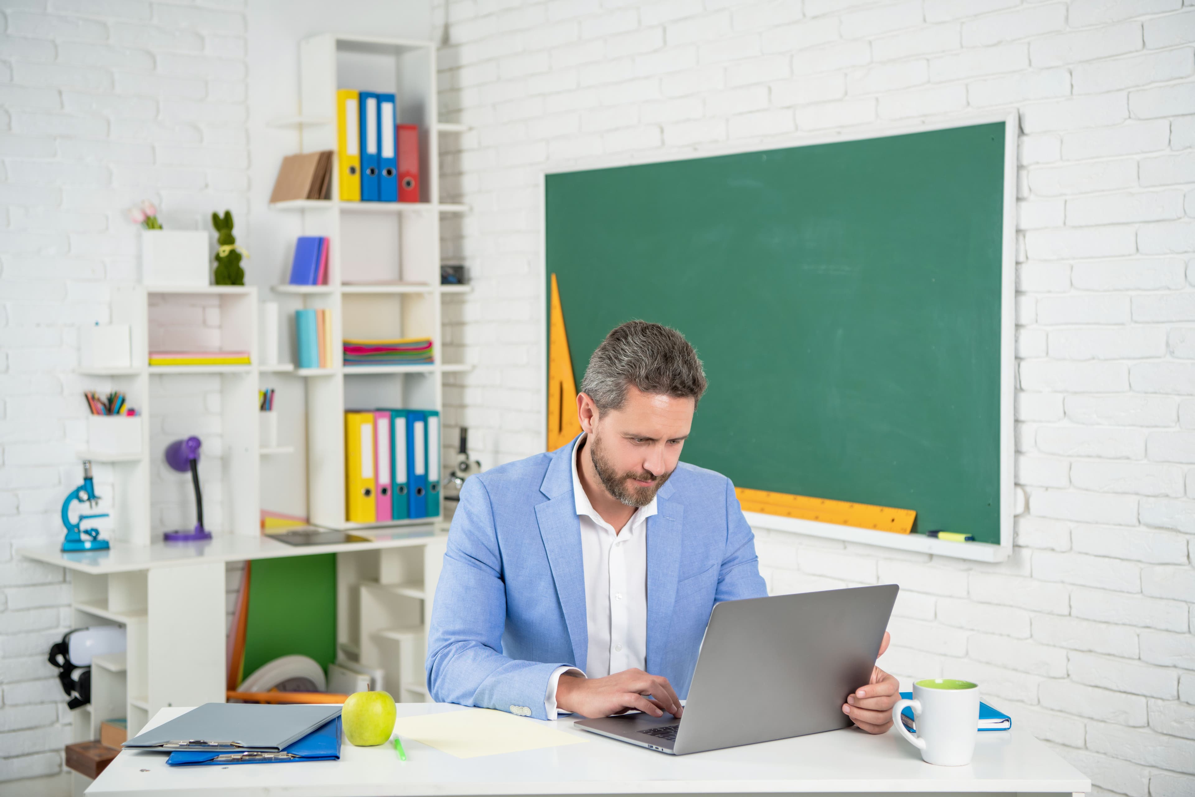Teacher in classroom with a computer